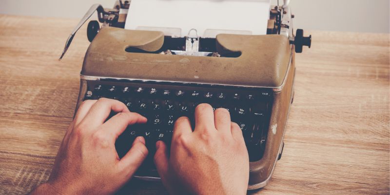Hands typing on an old typewriter